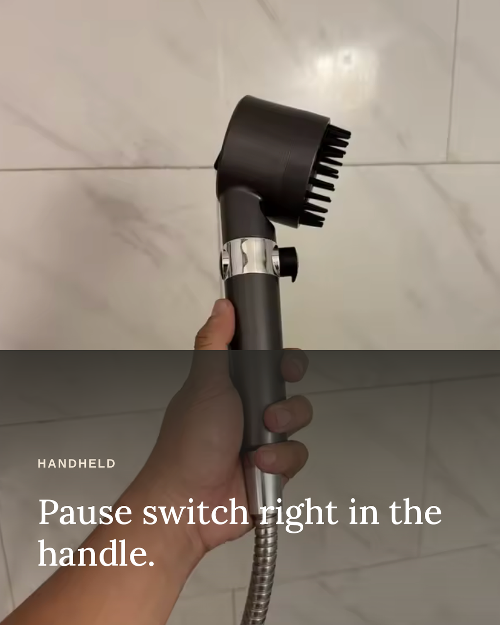 Glowfall handheld filtered showerhead held in hand, showing the pause switch on the handle.